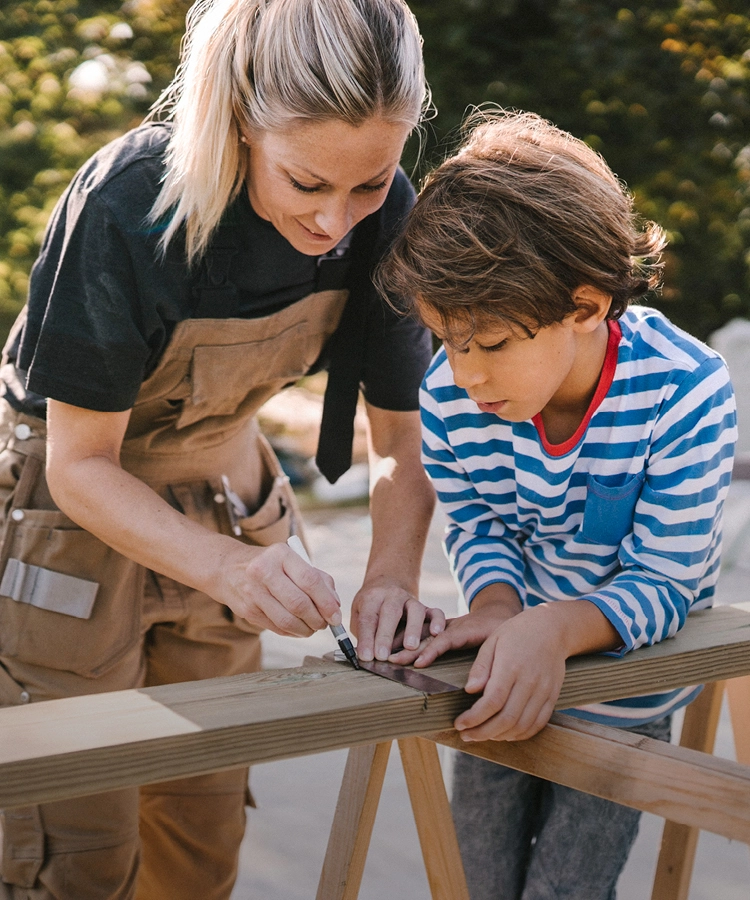 A mother and son measuring a piece of timber