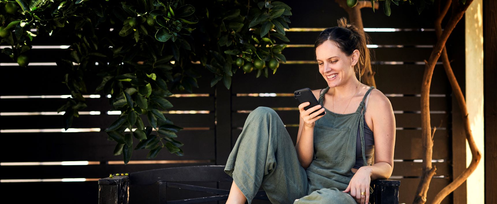 A woman sits and reads her phone