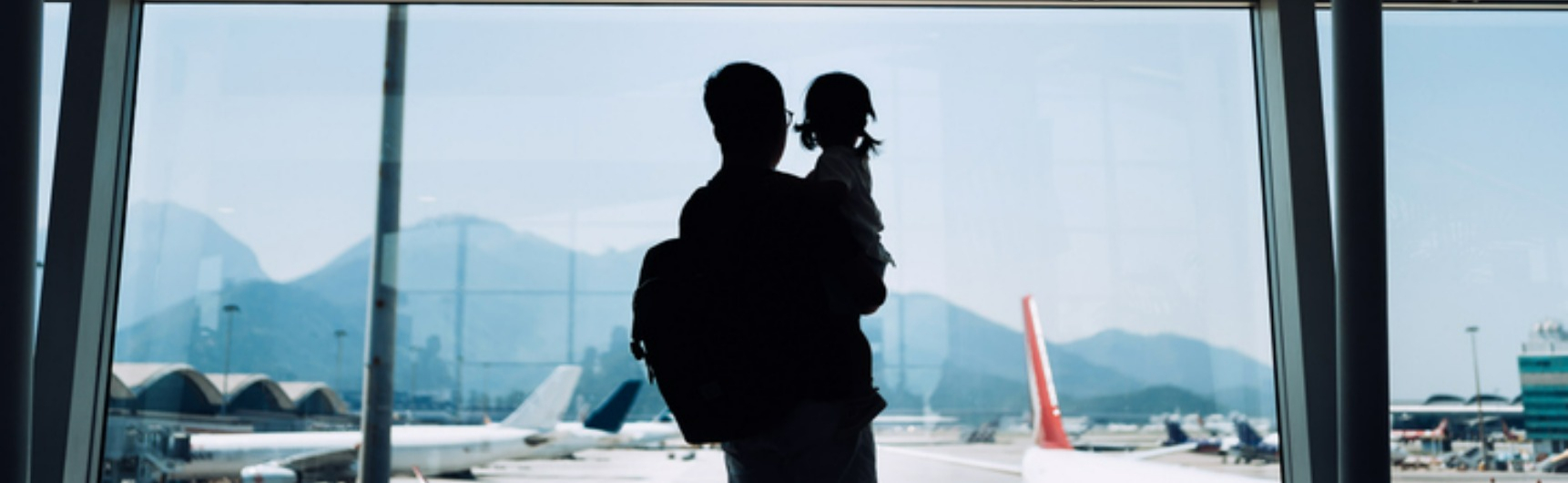 A man and child look at planes in the airport