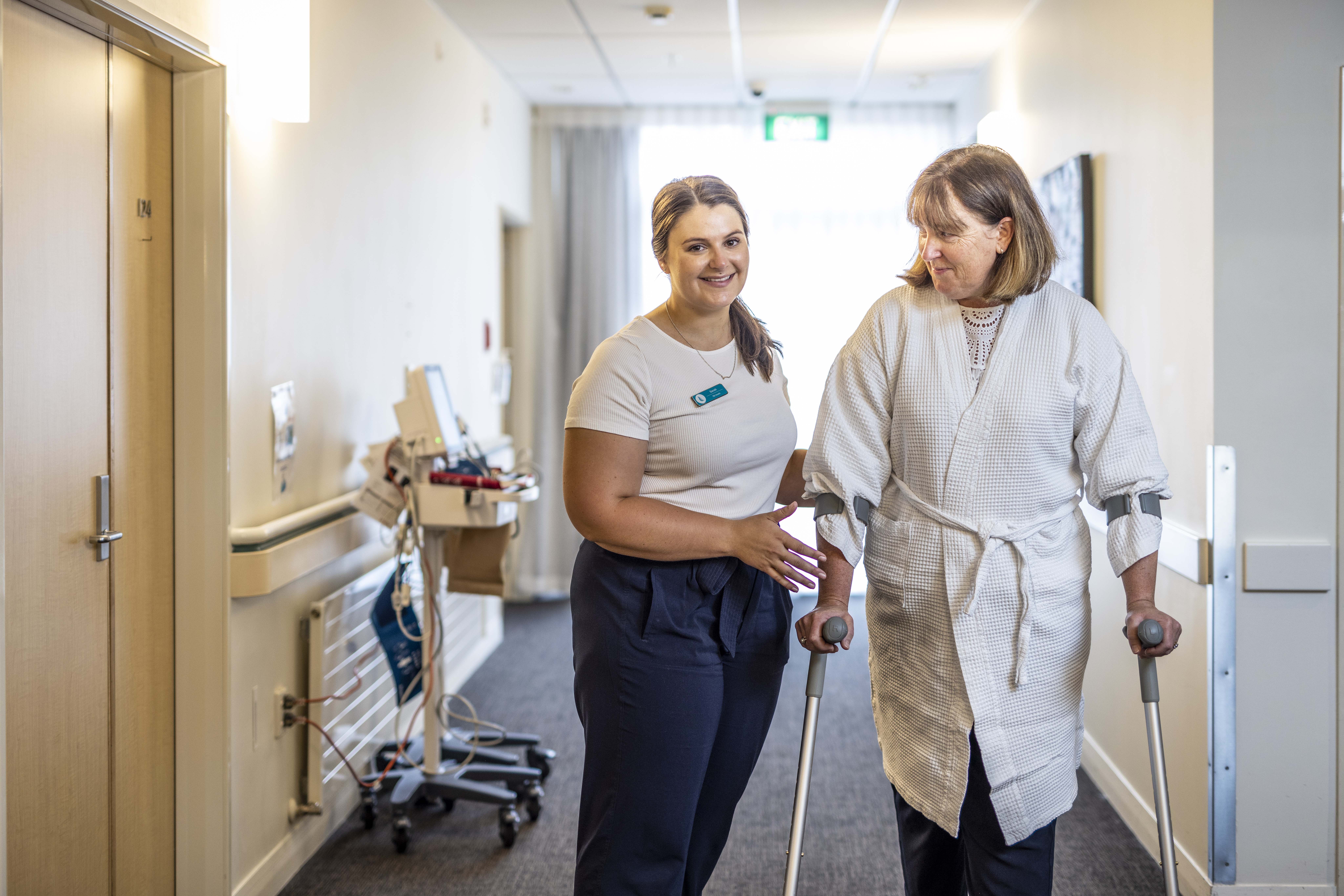 A nurse helps a patient walk