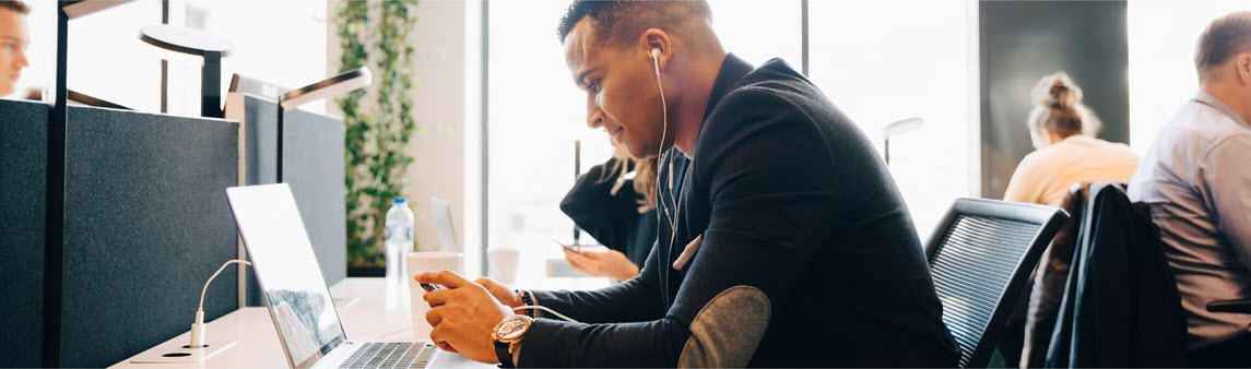 Office worker listening to music at his desk