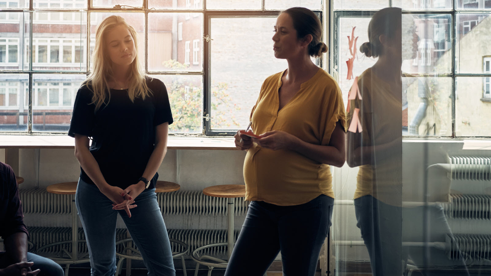 A pregnant woman leading an office meeting