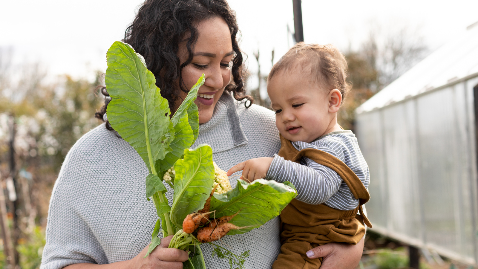 A woman and child look at a plant 