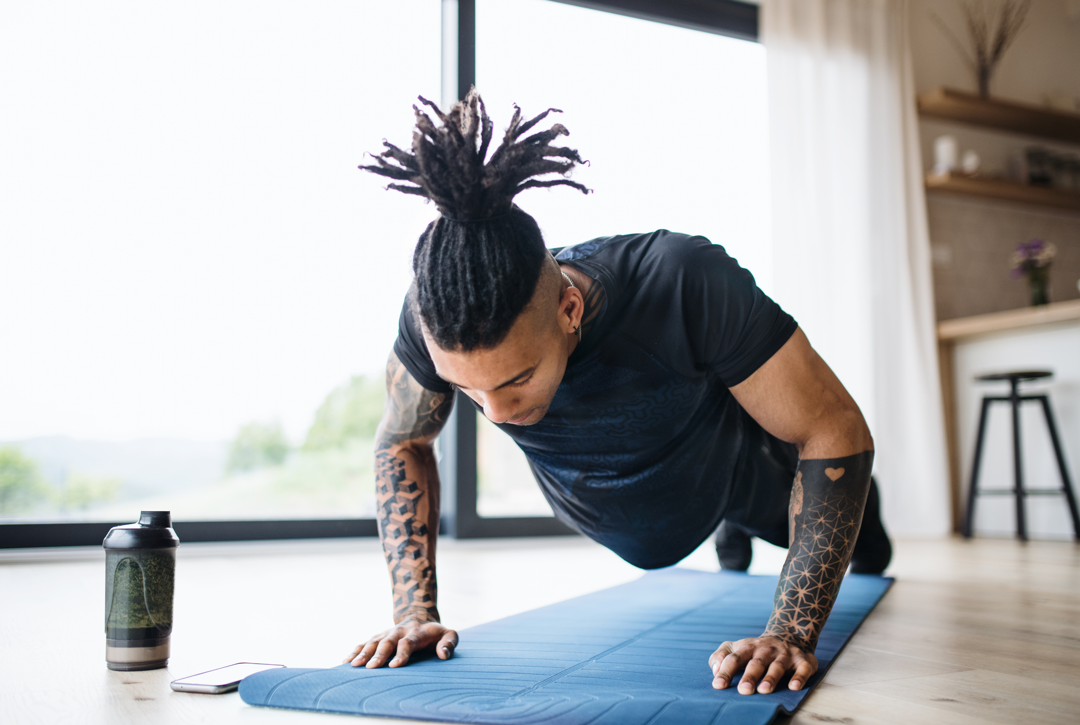 A man is doing push ups on a mat at home