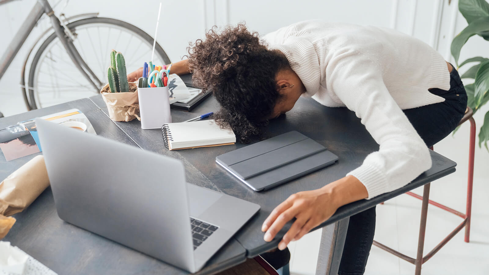 A woman has her head on the desk while working