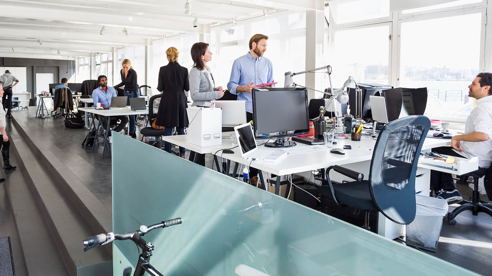 People talk over the desk in an office