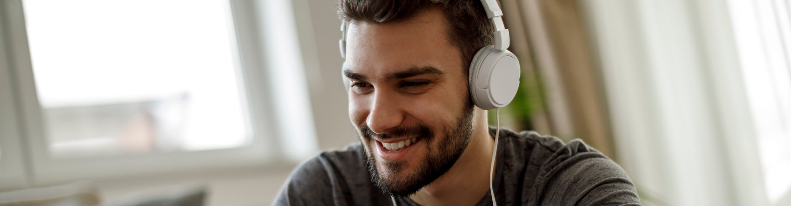 A man smiles with headphones on
