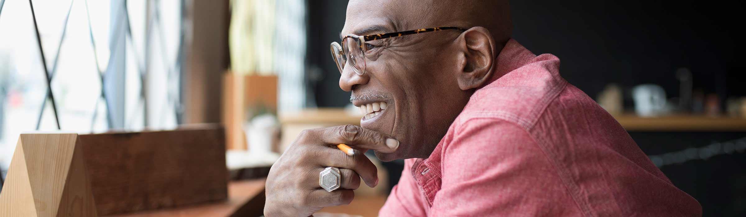 A man smiles while looking out of the window