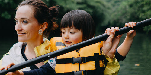 A mother and daughter rowing in a canoe