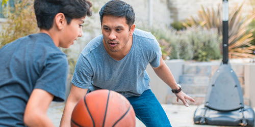 A father and son playing basketball