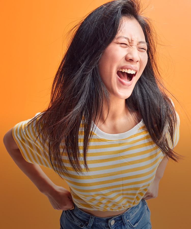 A woman shouts in front of an orange background