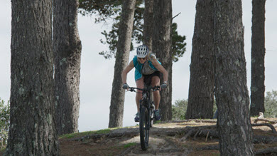 A lady riding her mountain bike in a park
