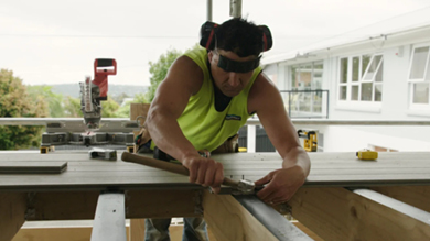 A man cutting wood on a work bench