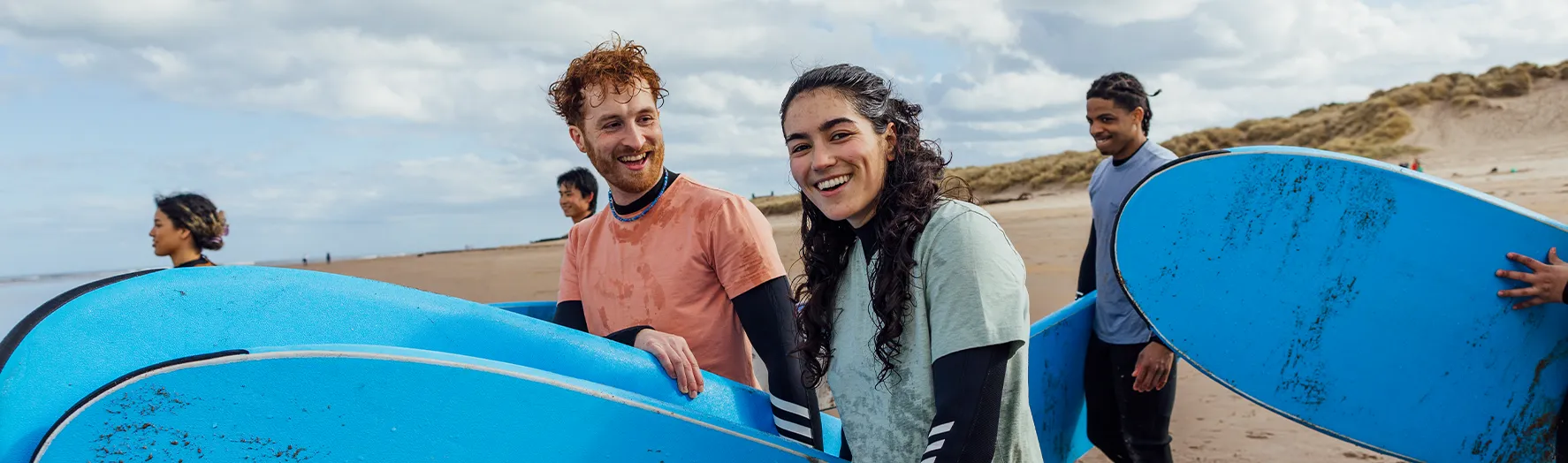 A group of friends carrying their surf boards