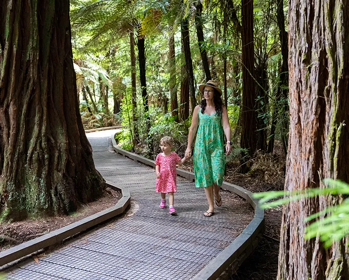 A mother and daughter walking a forest track