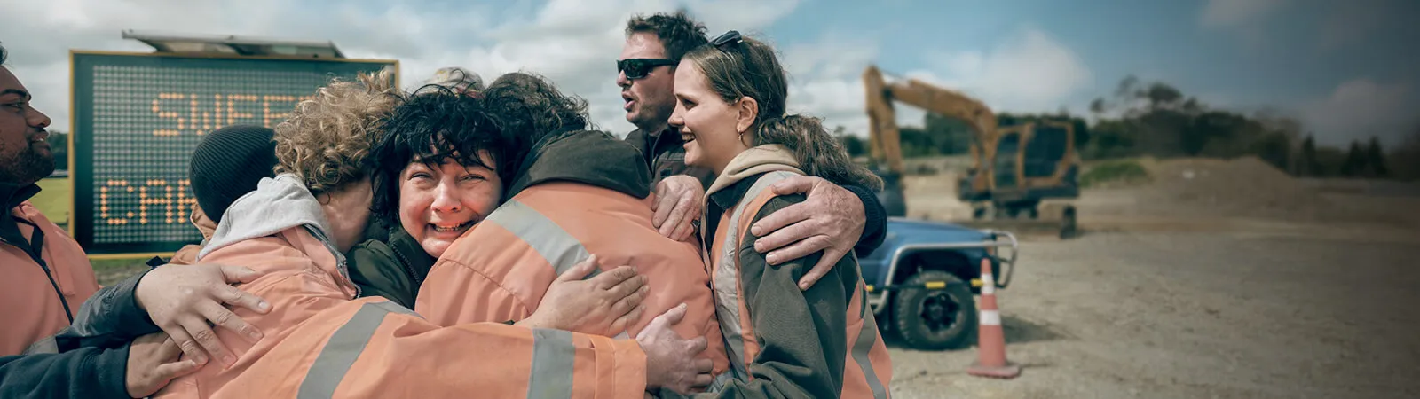 A work crew share a hug together